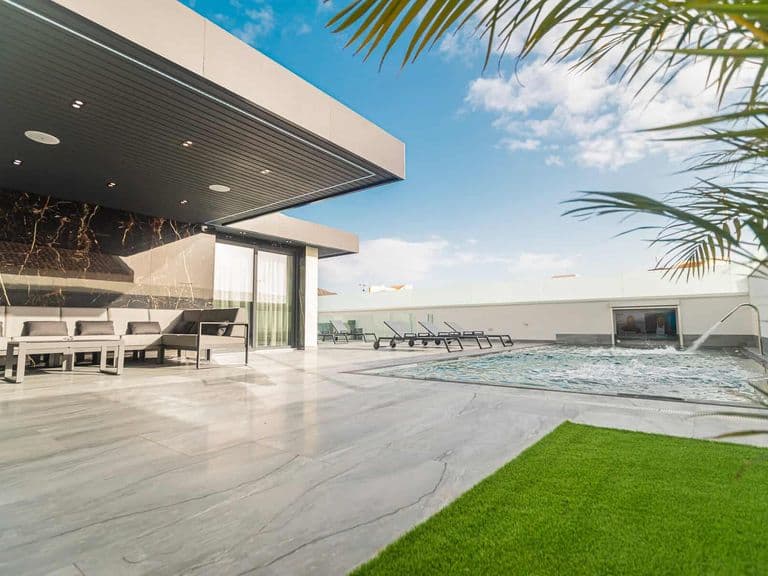 Terraza moderna con piscina, tumbonas y zona de comedor exterior