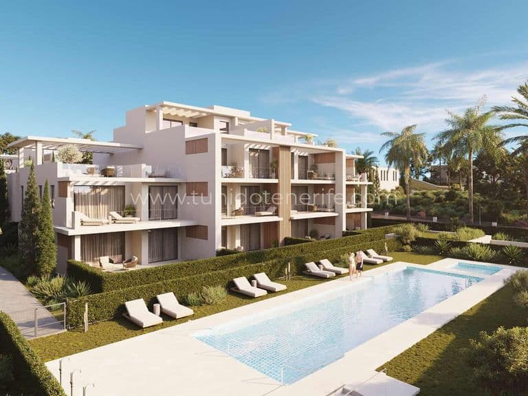 Piscină exterioară înconjurată de șezlonguri și grădini