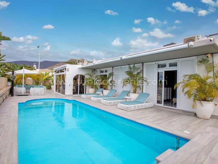 Piscina exterior con tumbonas y cielo despejado