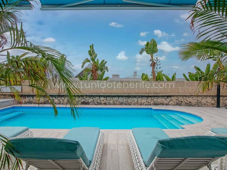 Piscina con tumbonas y vistas al mar