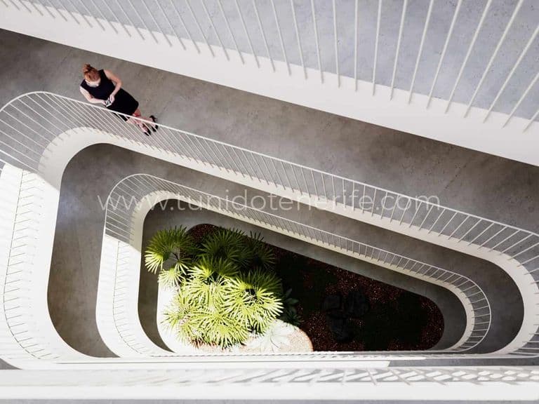Scară interioară cu balustrade albe și plantă centrală