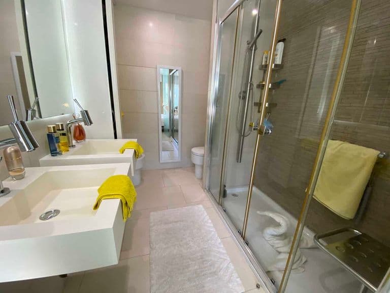 Modern bathroom with glass shower double sink and mirror