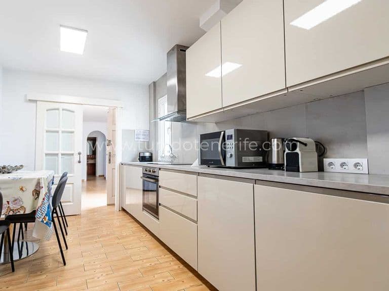 Cucina moderna con mobili beige e pavimento in legno