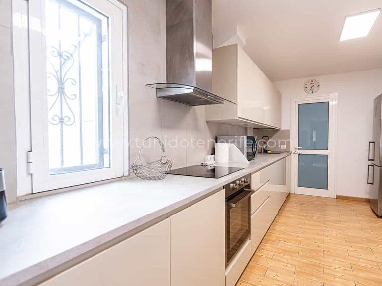 Cucina moderna e luminosa con mobili bianchi e finestra