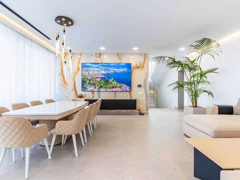 Comedor moderno con mesa, sillas, sofá y televisor
