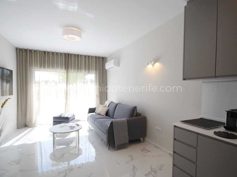Bright living room with gray sofa, white table and beige curtains