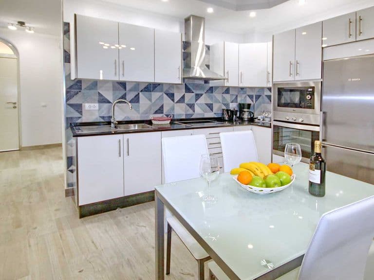 Cucina moderna con tavolo in vetro ed elettrodomestici inox