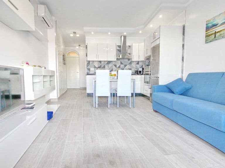 Soggiorno moderno con divano blu e cucina aperta