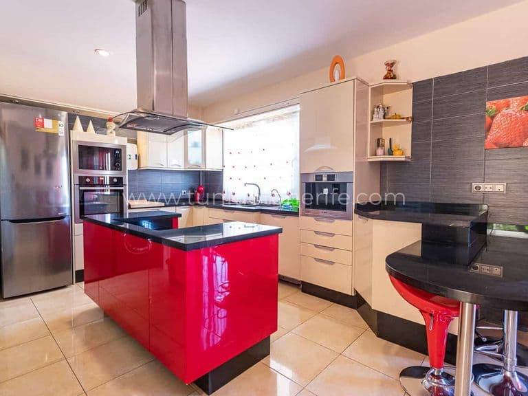 Cuisine moderne avec îlot rouge et électroménager en inox