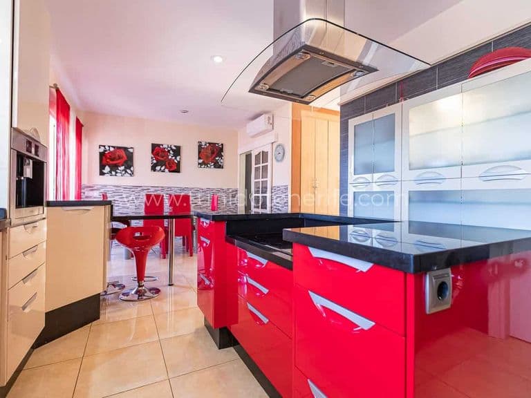 Cuisine moderne avec meubles rouges et plan de travail noir