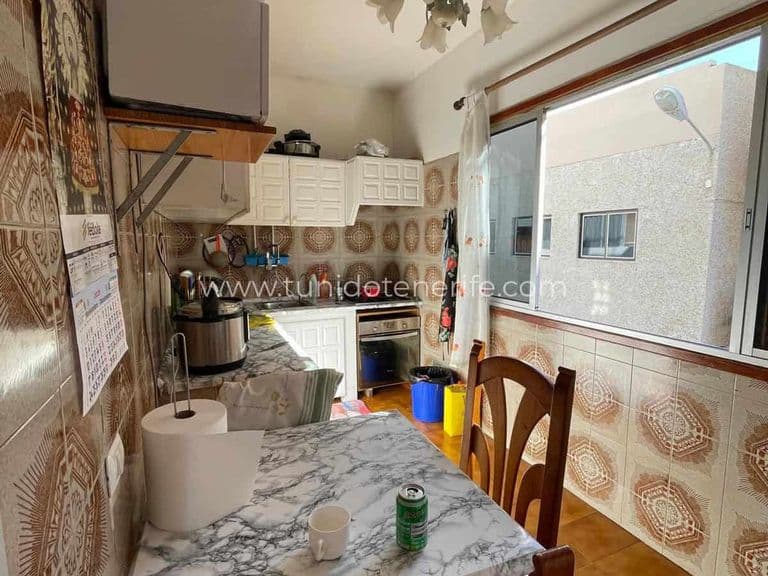 Small kitchen with table, white cabinets and large window