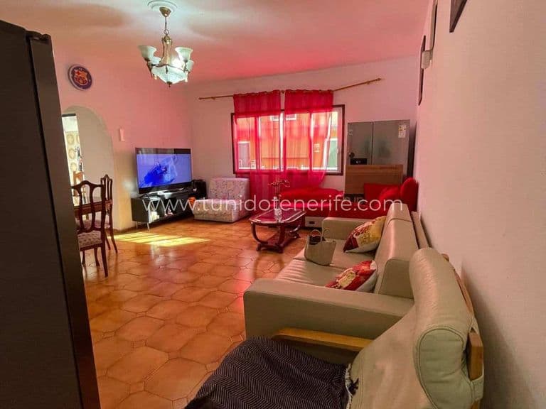 Spacious living room with sofas, television and red curtains