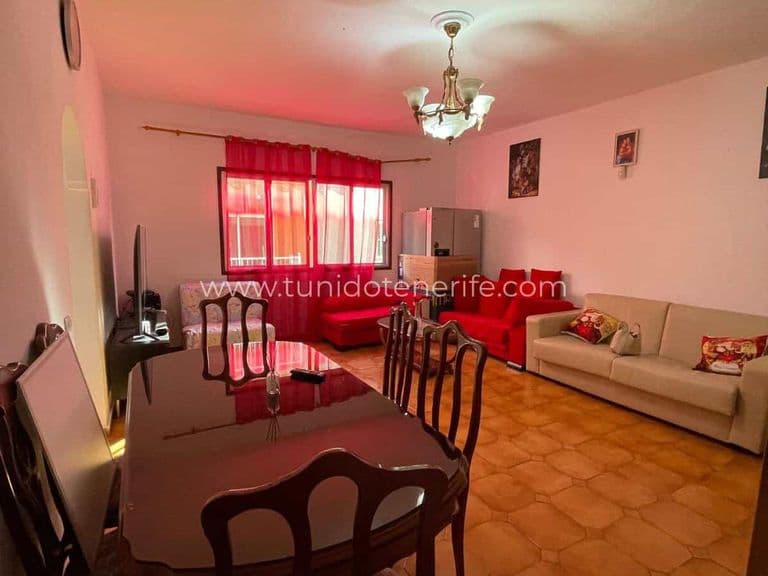 Living room with red sofa, dining table and curtained window