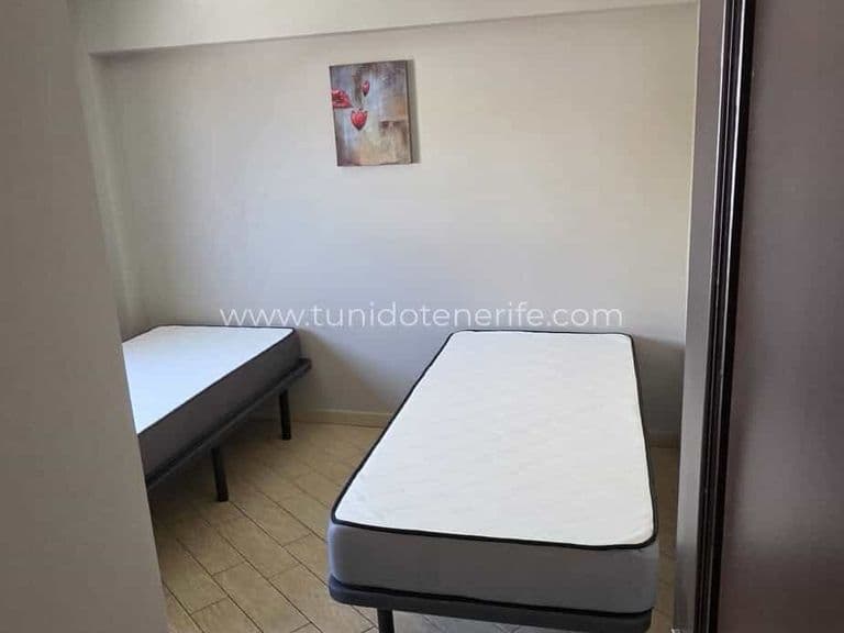 Dormitorio pequeño con dos camas individuales y pared decorada