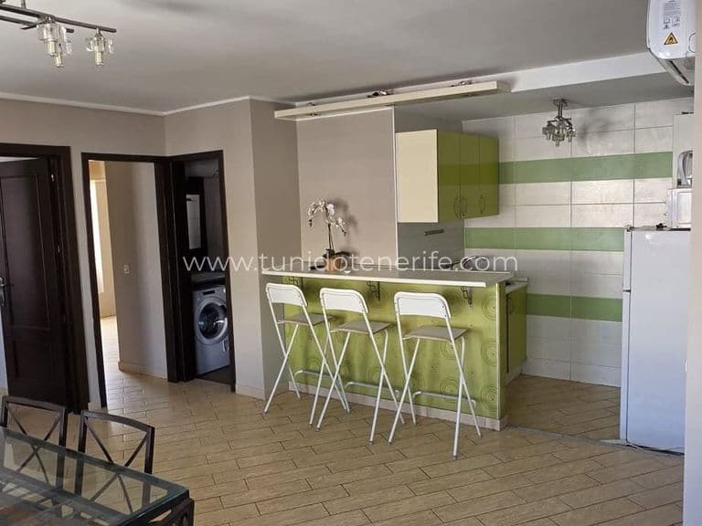 Cocina abierta con barra y taburetes blancos