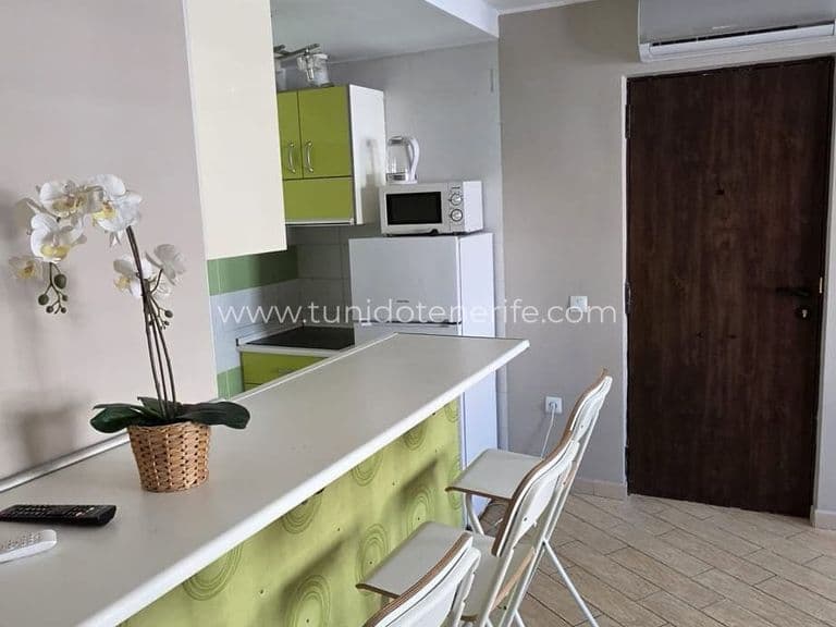 Cocina abierta con barra y taburetes blancos