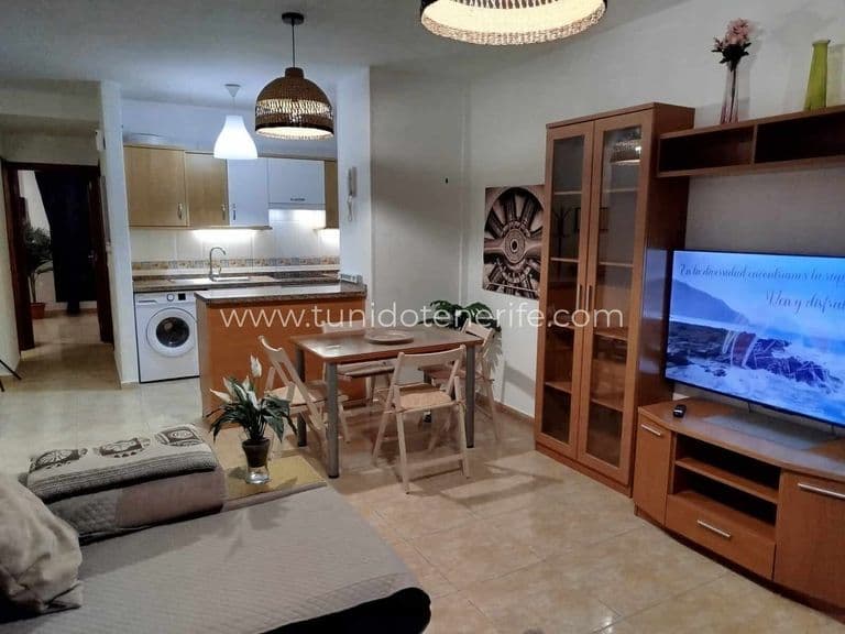 Salón comedor con cocina abierta y mobiliario de madera