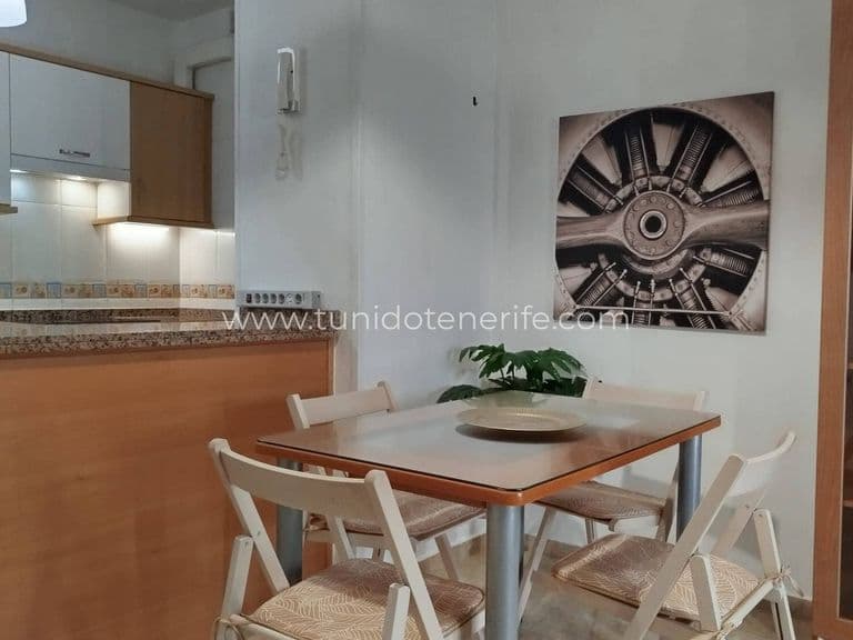 Comedor con mesa, sillas y cocina abierta