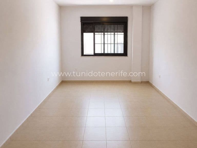 Habitación vacía con suelo de baldosa y ventana