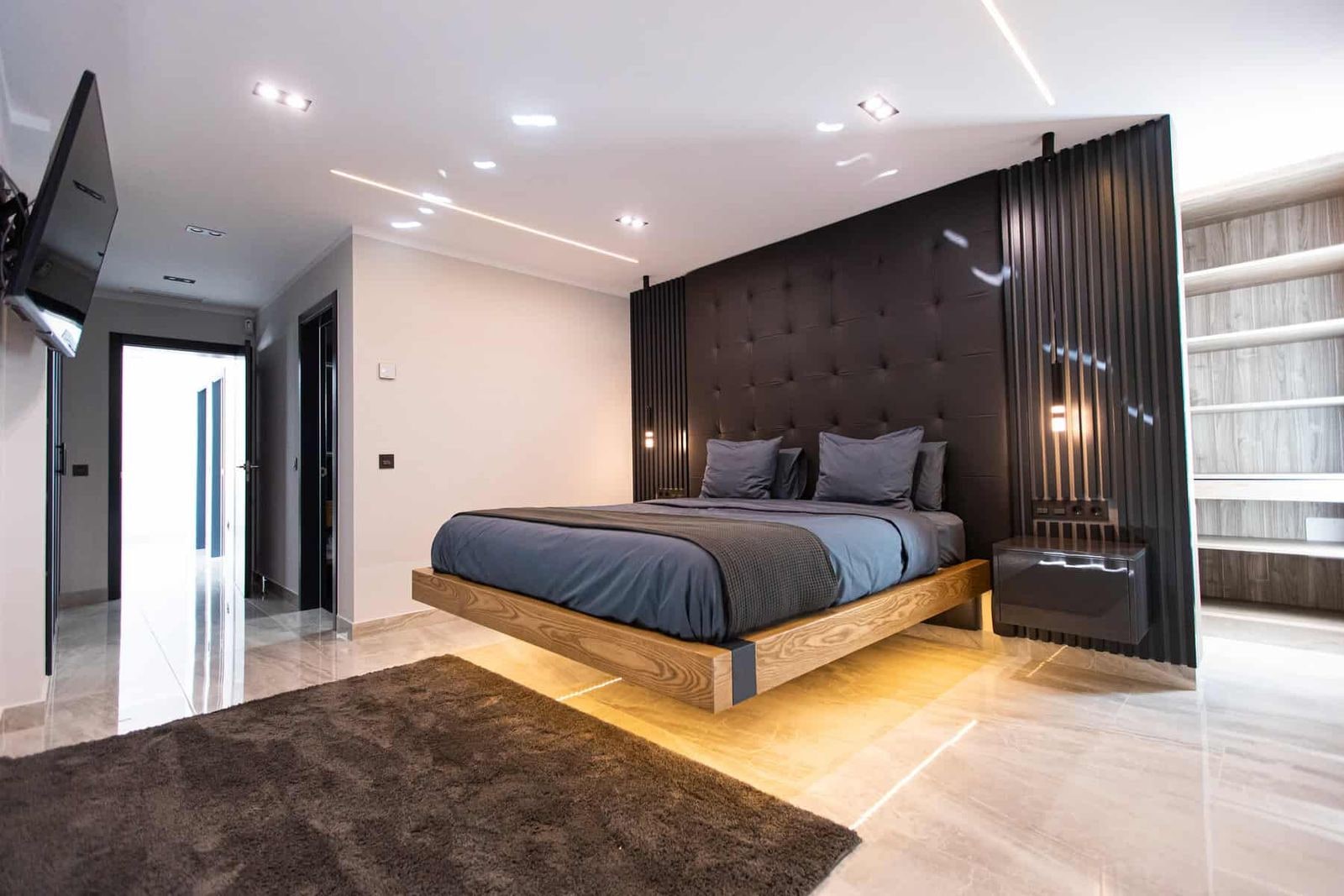 Dormitorio moderno con cama tapizada y iluminación empotrada