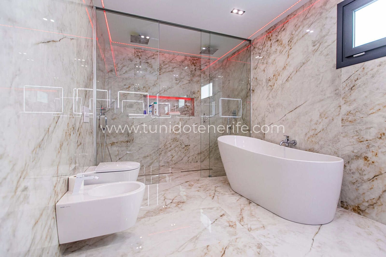 Baño moderno con bañera exenta, ducha y sanitarios blancos