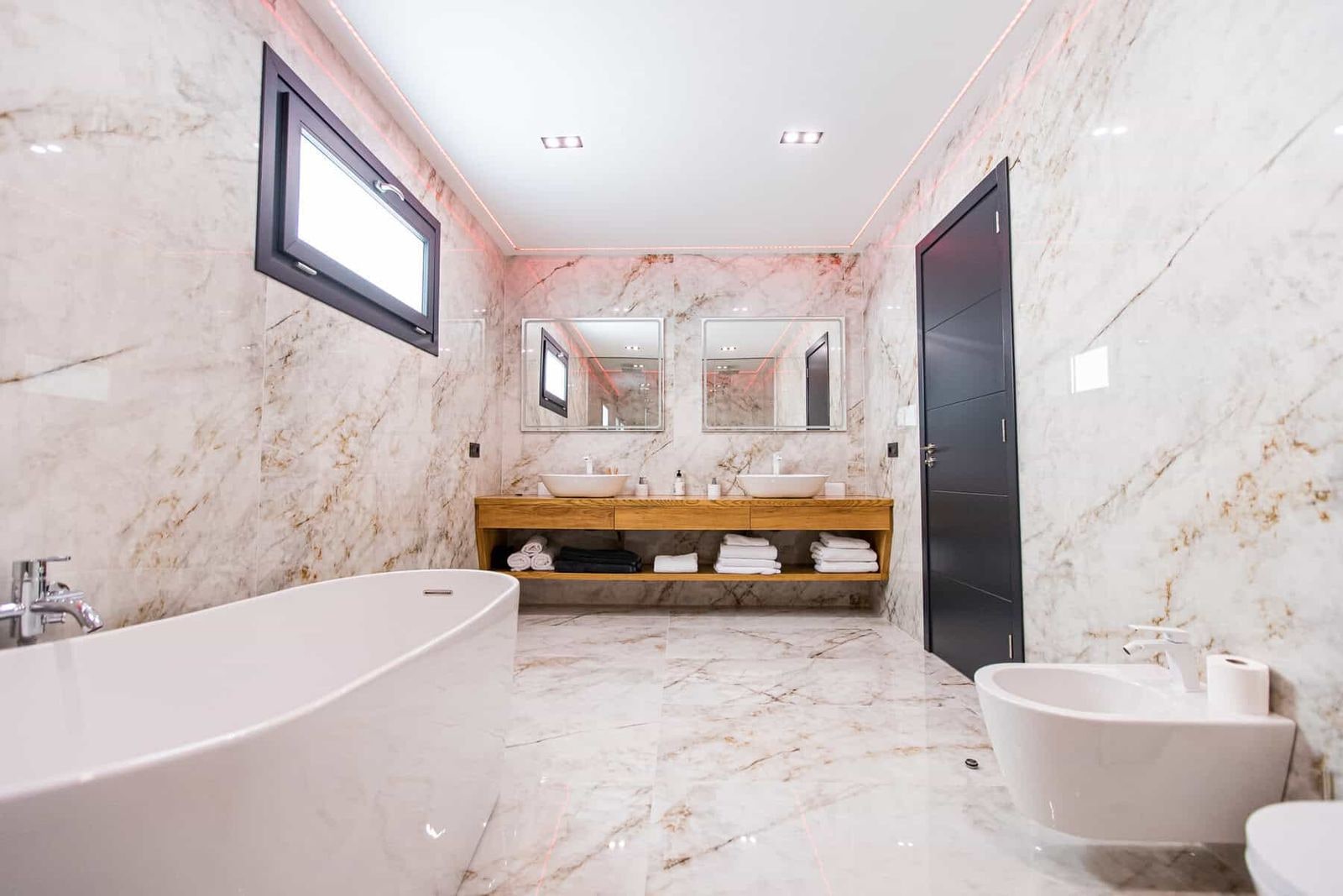 Baño moderno con bañera, lavabo doble y espejo
