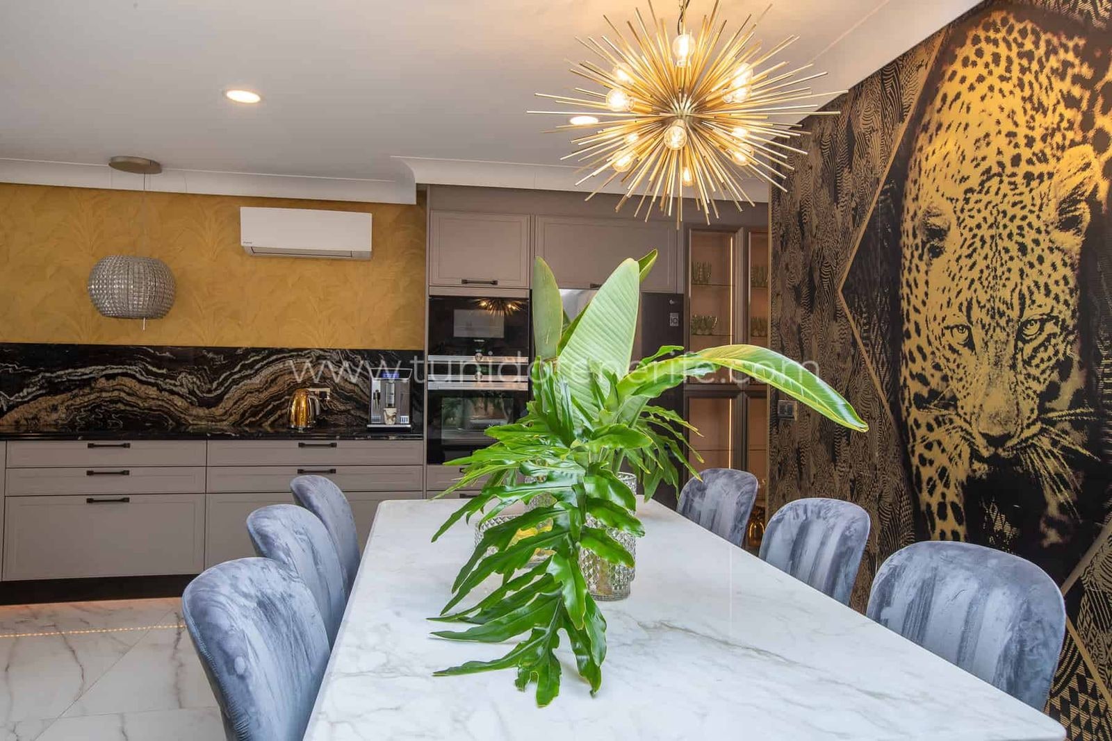 Comedor moderno con mesa blanca, sillas acolchadas y lámpara colgante