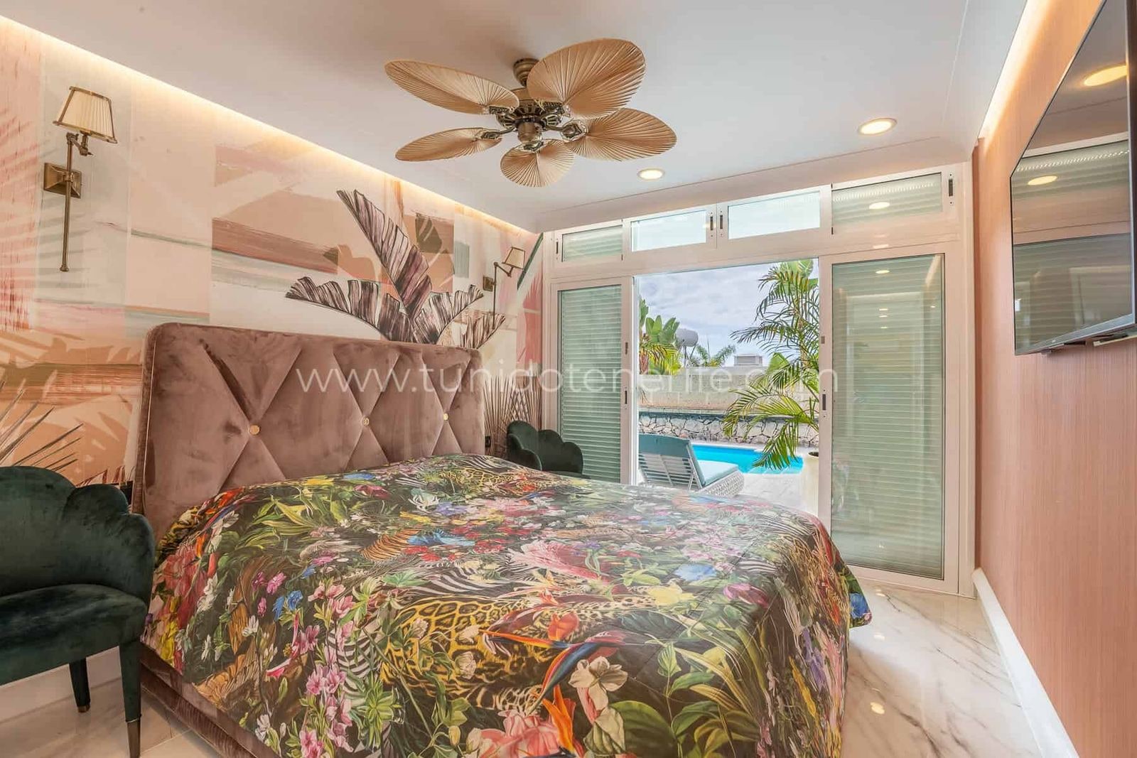 Dormitorio con cama floral y salida a la terraza