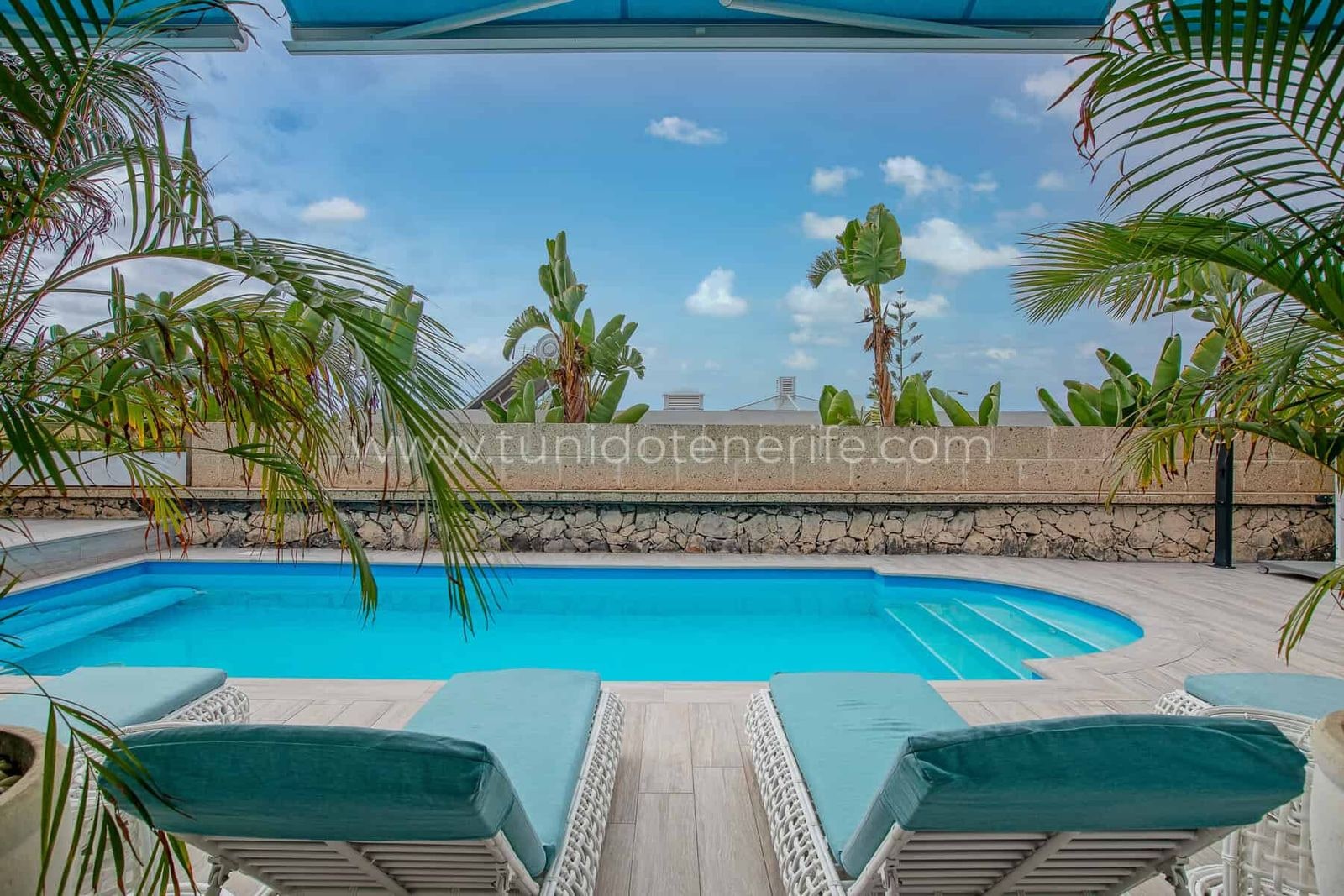 Piscina con tumbonas y vistas al mar