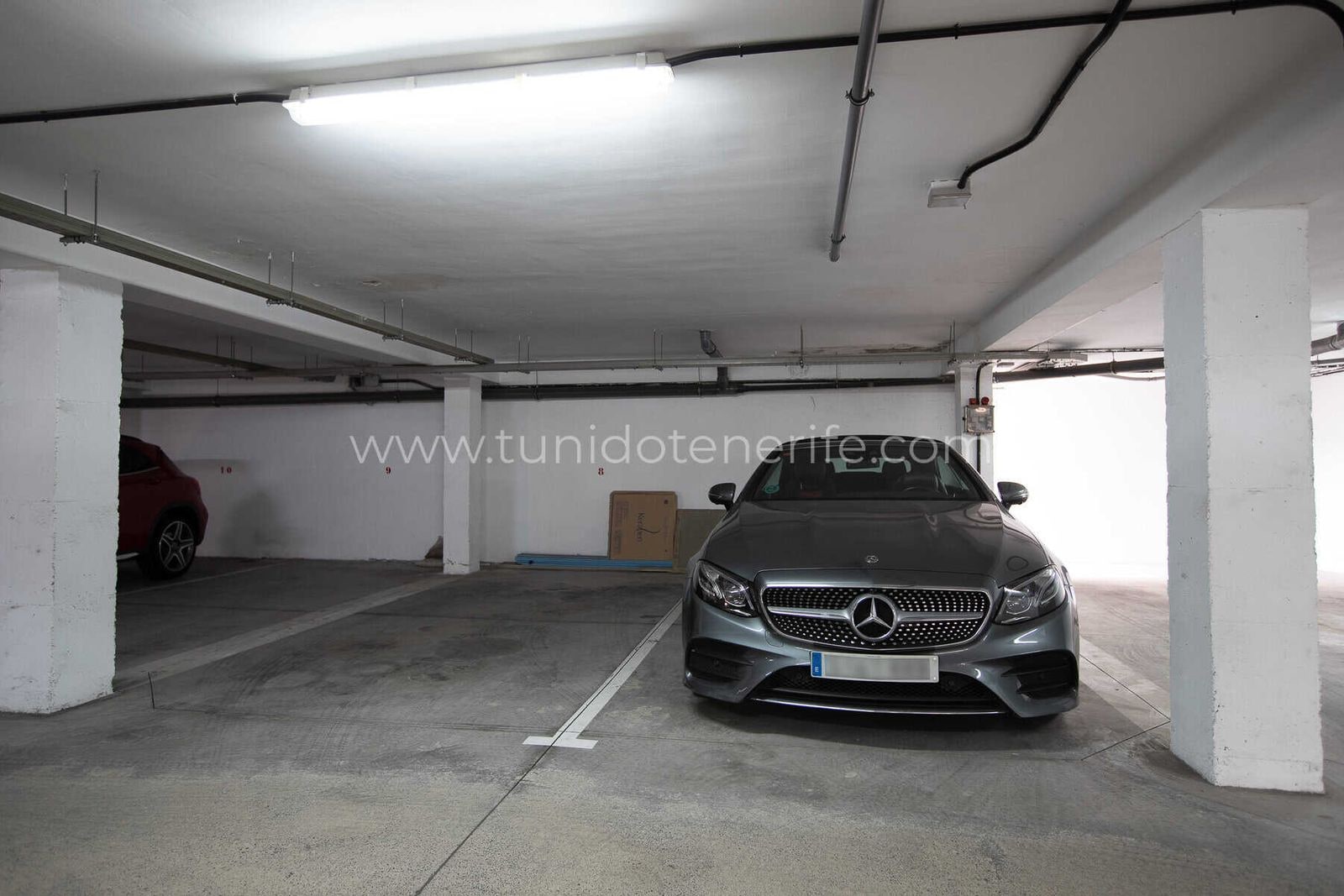 Plaza de garaje interior con coche aparcado