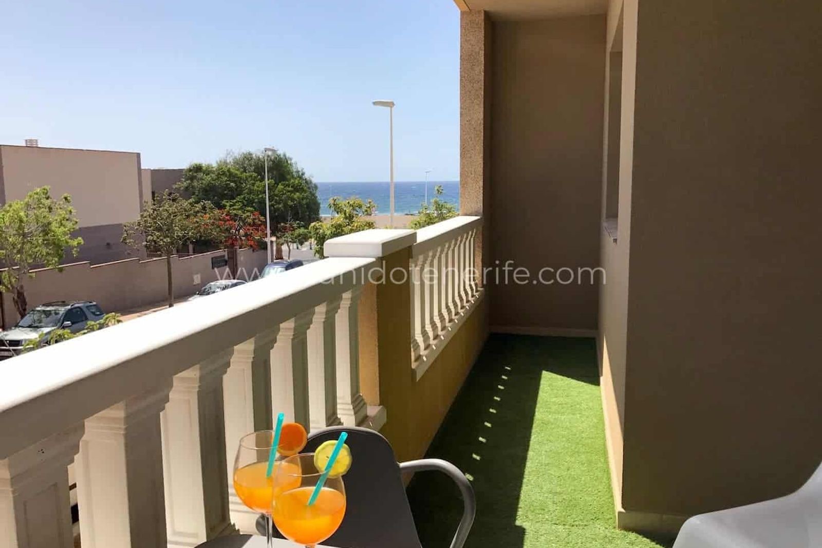 Balcon îngust cu vedere la mare și masă cu băuturi