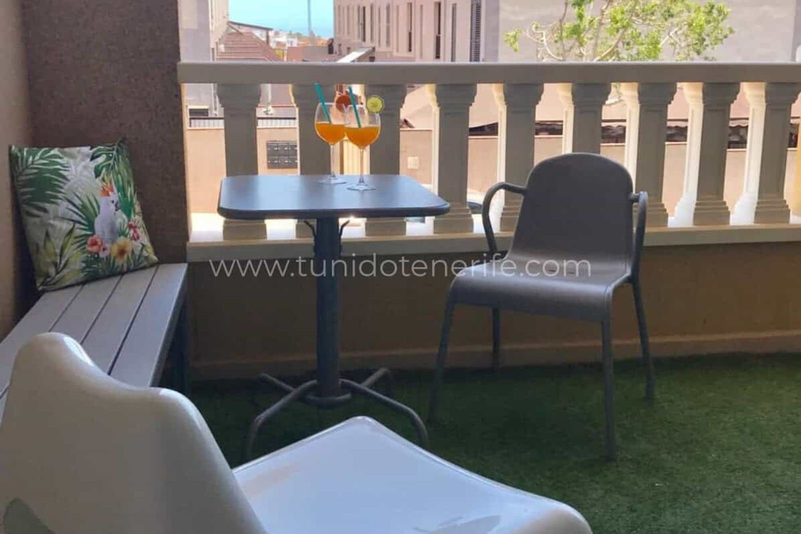 Balcon cu masă, scaune și podea din gazon artificial