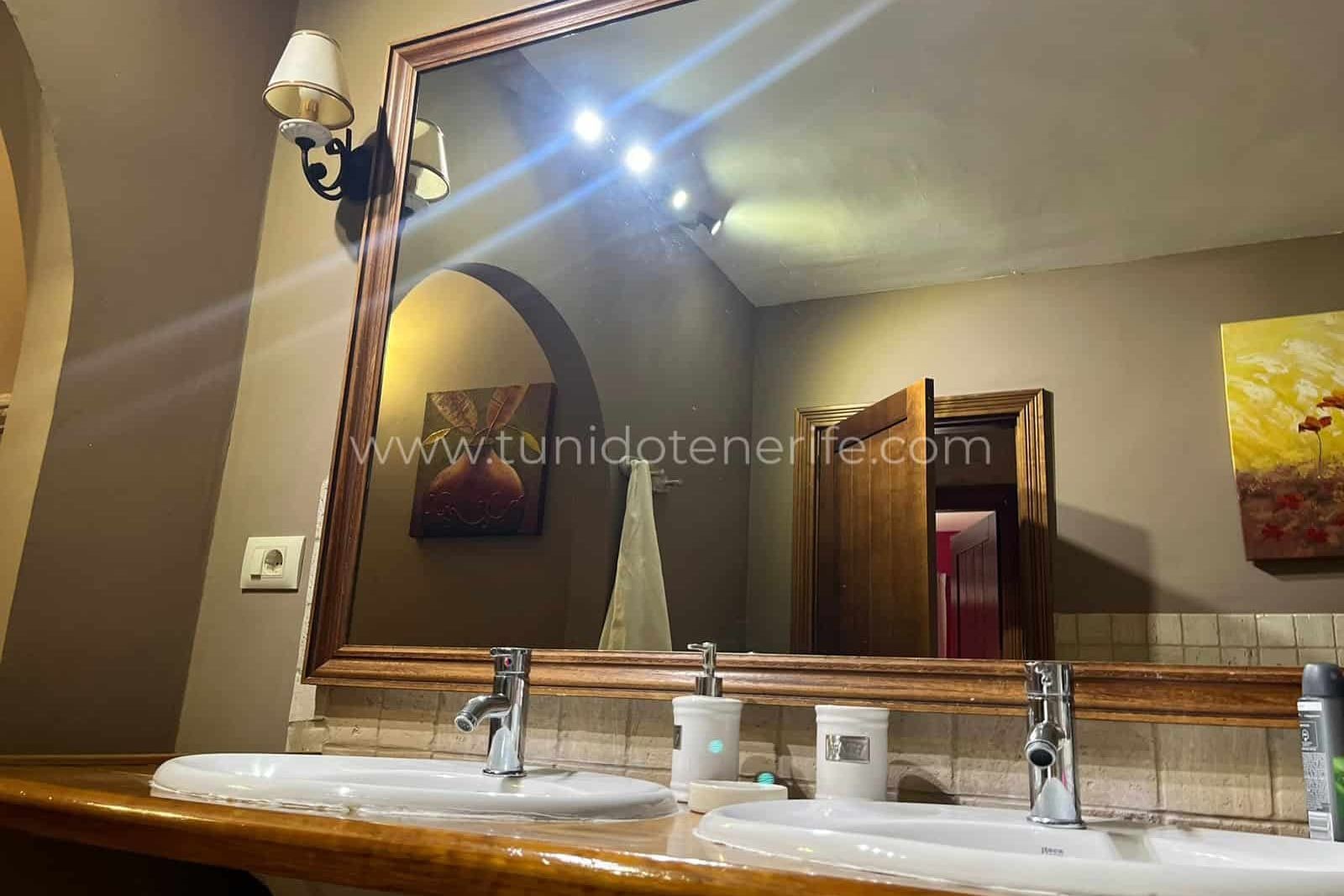 Double sink with large mirror and wall sconces