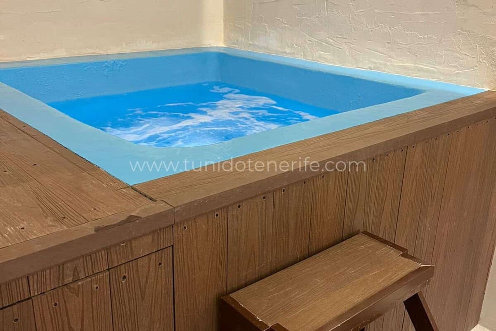Small indoor wooden pool with bench