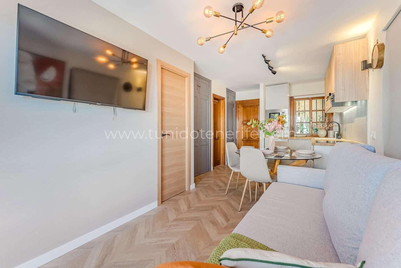 Living cu zonă de dining luminoasă, bucătărie deschisă și canapea
