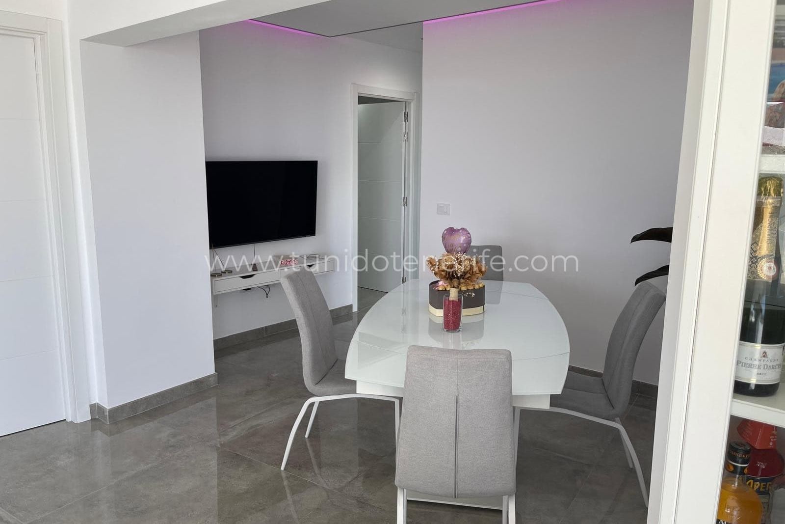 Zonă de dining modernă cu masă din sticlă și scaune tapițate