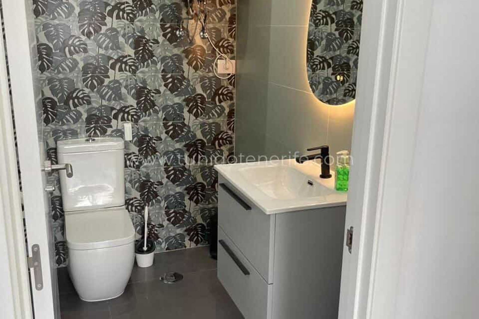 Baie cu lavoar modern și tapet tropical