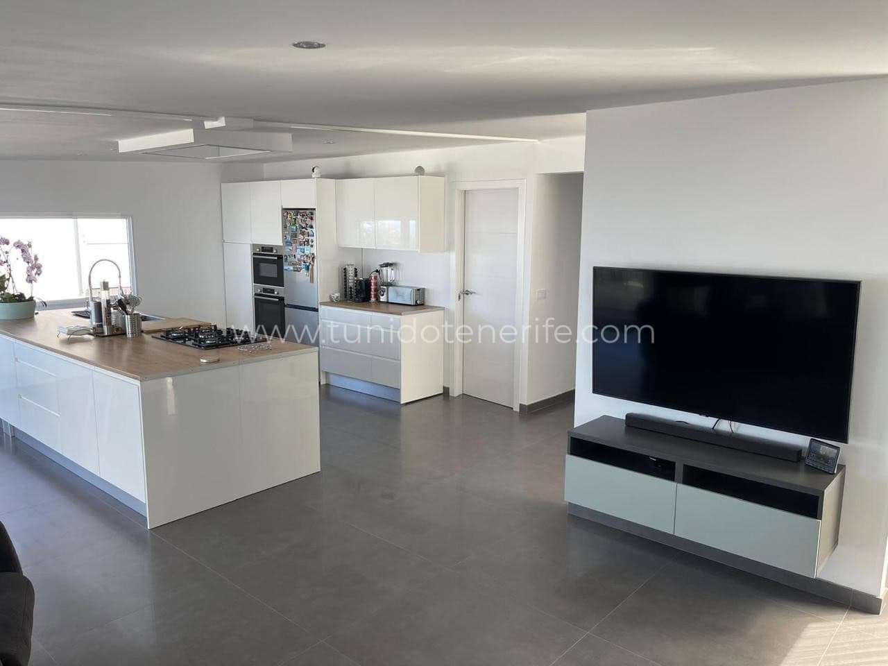 Living open-space cu bucătărie modernă și televizor