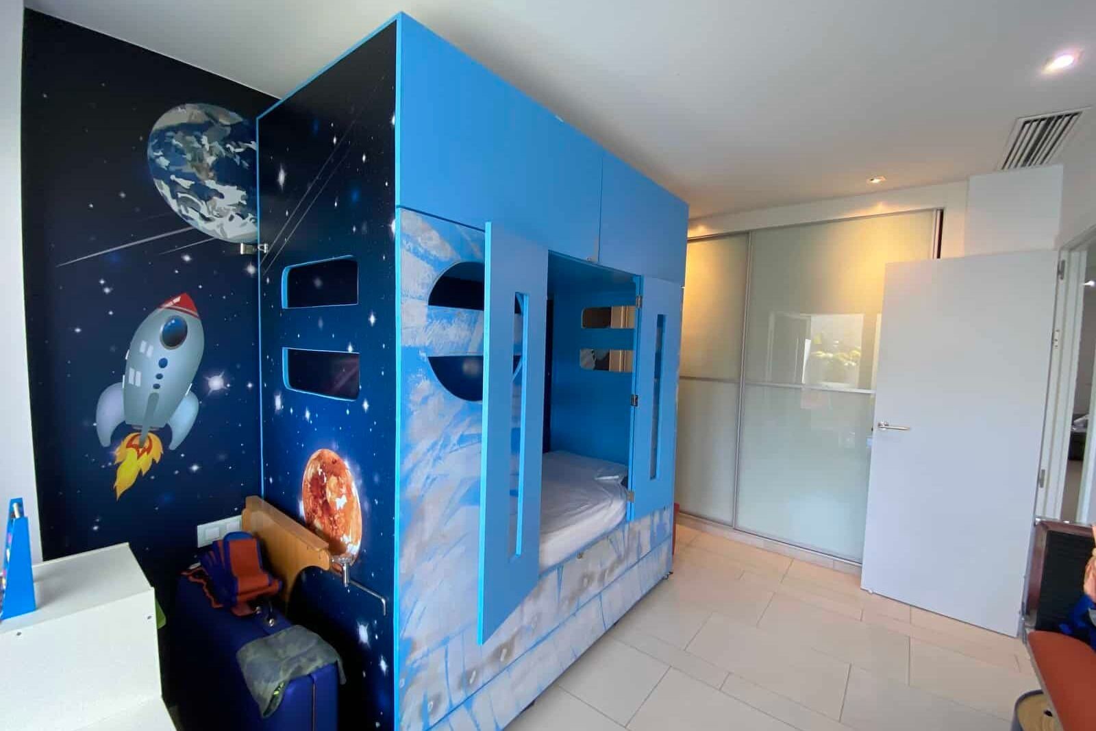 Children's bedroom with bunk beds and space mural
