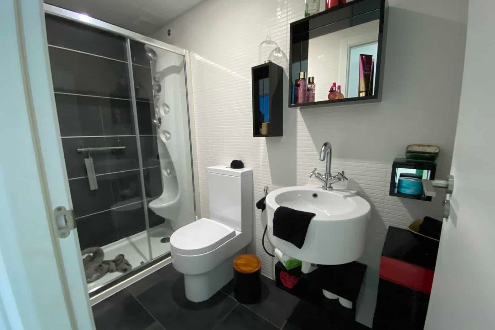 Bathroom with shower, sink and side cabinet