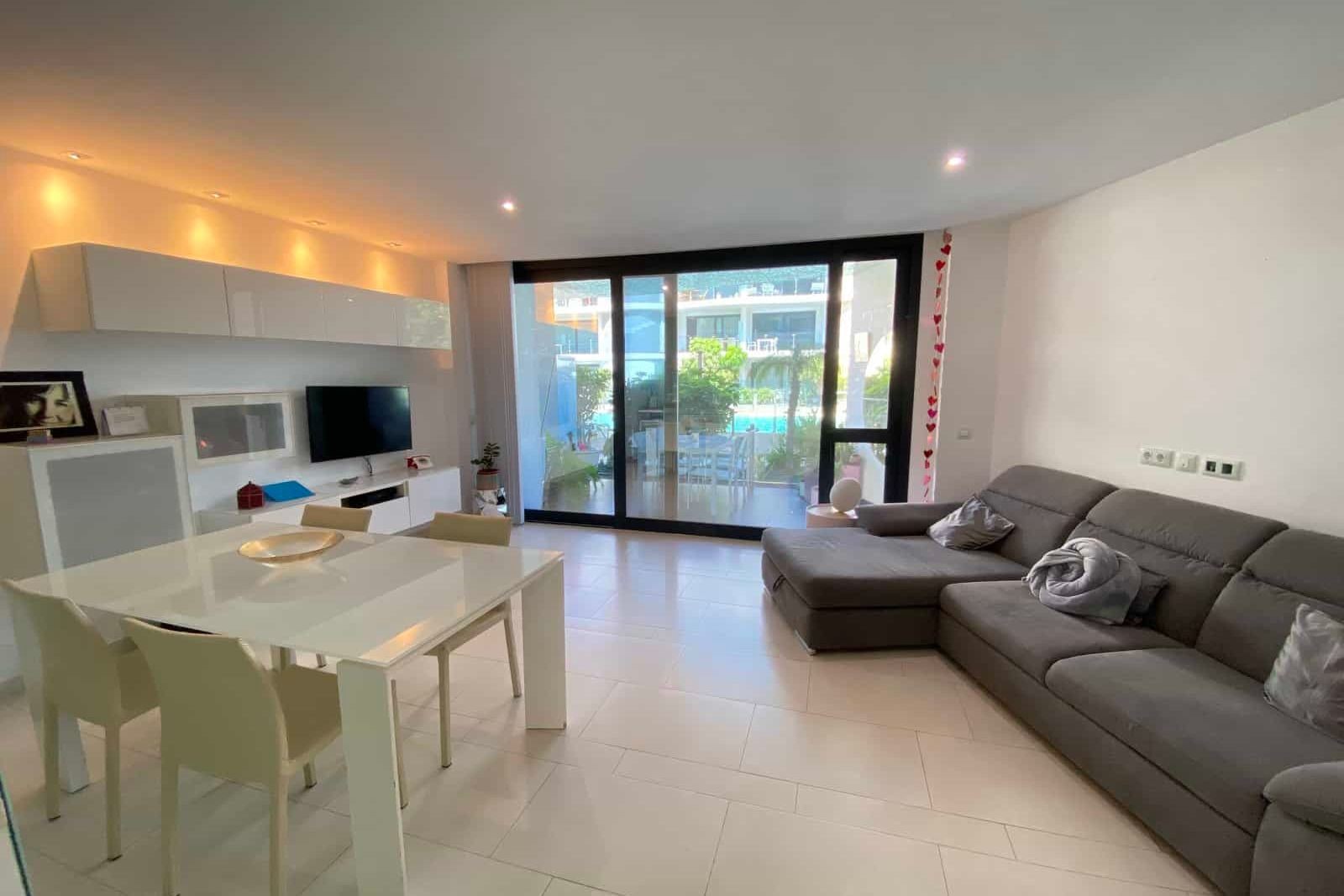 Living-dining room with gray sofa and white table