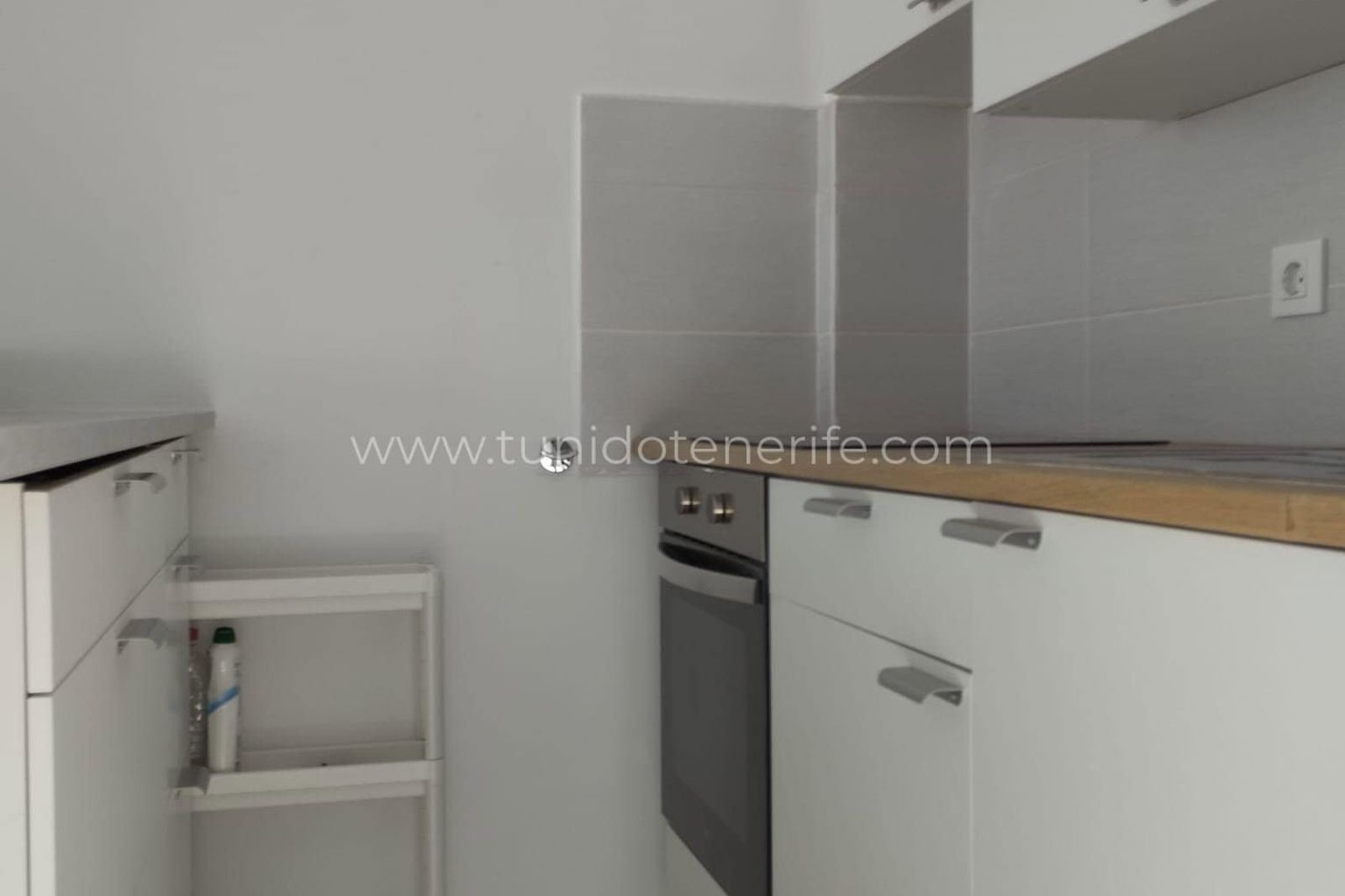 Bucătărie modernă cu mobilier alb și cuptor încorporat