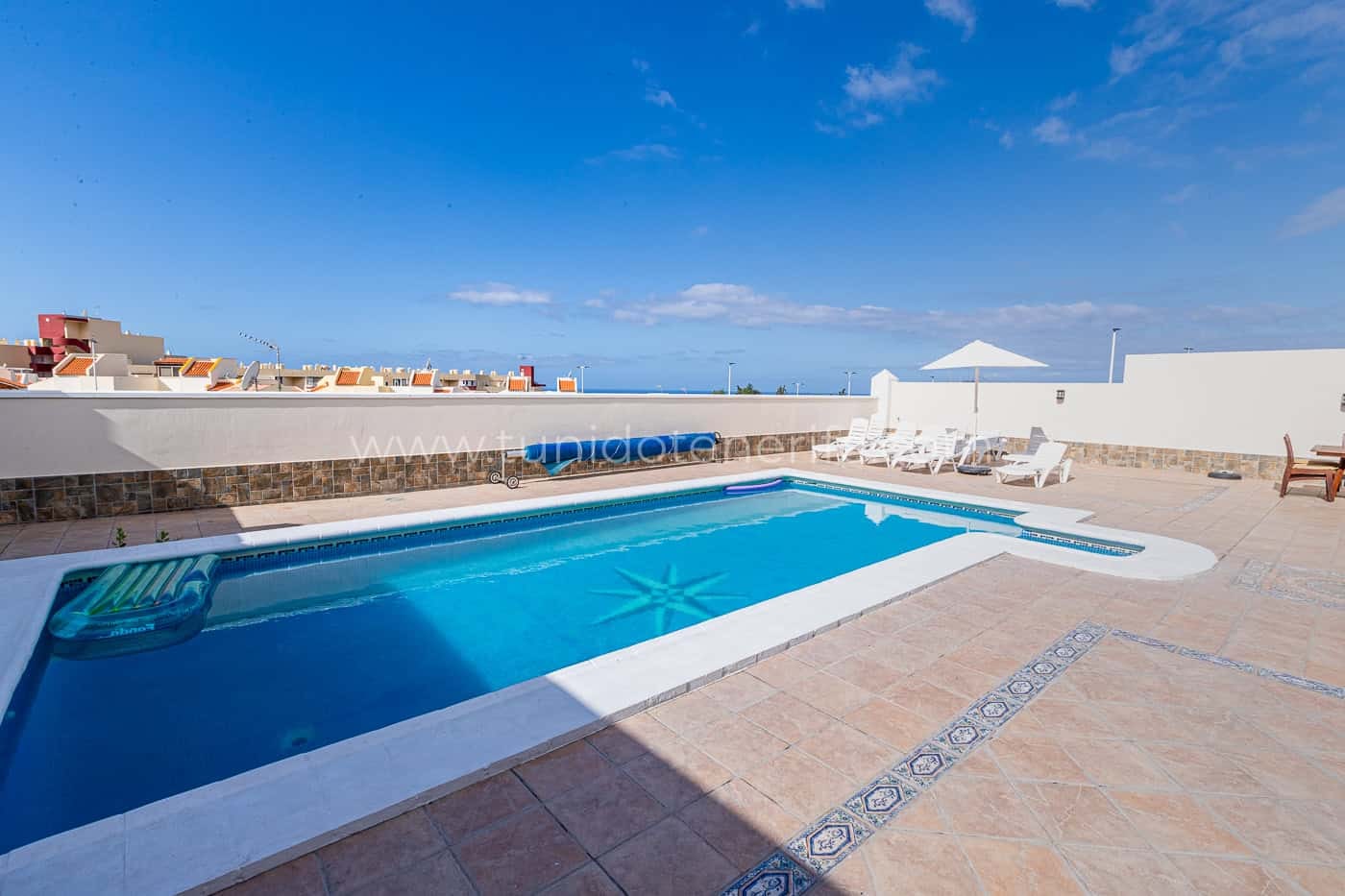 Piscina all'aperto con lettini e cielo sereno