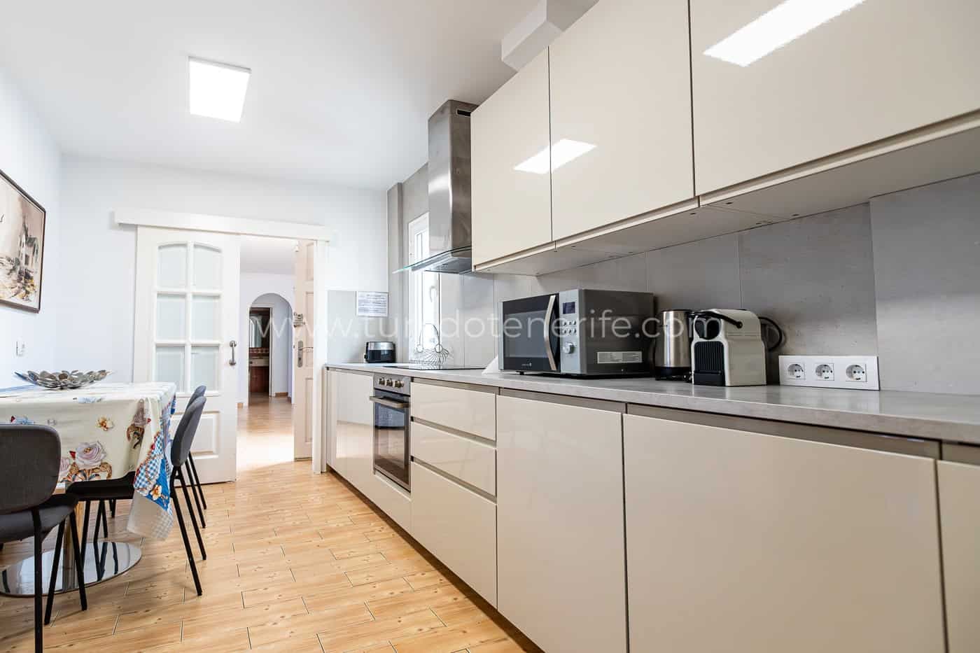 Cucina moderna con mobili beige e pavimento in legno