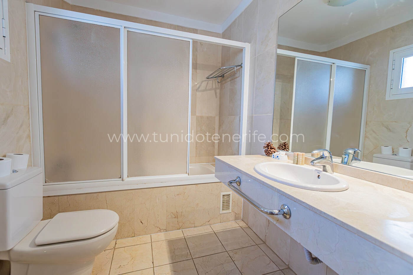 Bagno con vasca, lavabo e doccia con parete