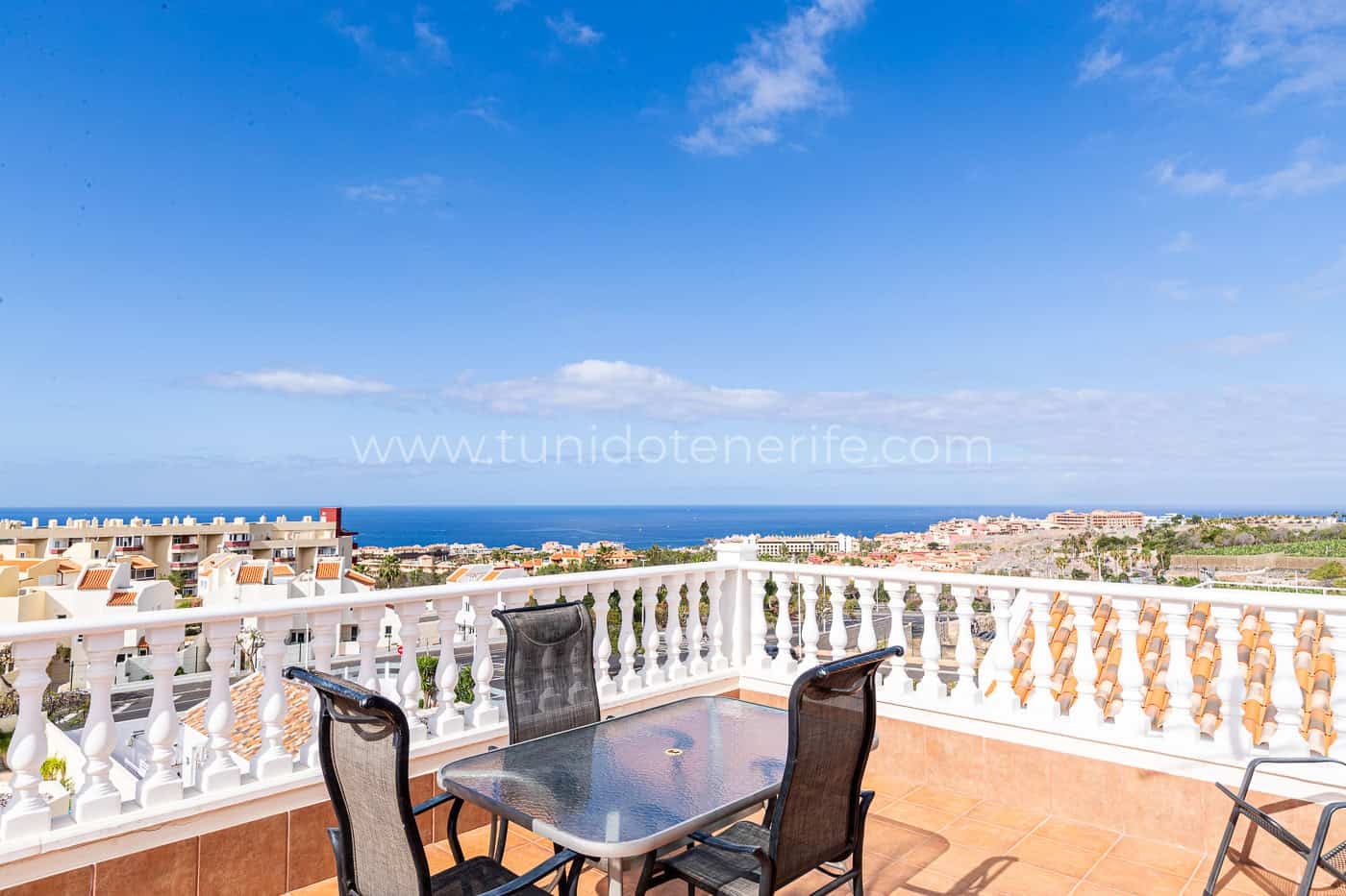 Terrazza con tavolo e sedie, vista mare e cielo sereno