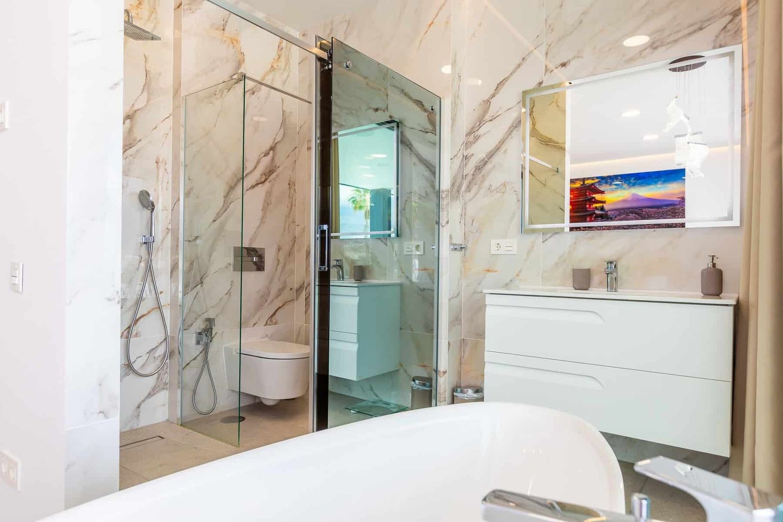 Baño moderno con ducha de cristal y bañera