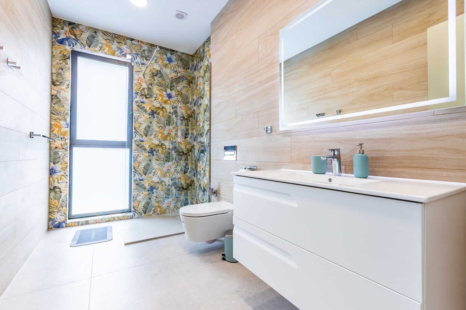 Baño moderno con papel pintado floral y mueble blanco