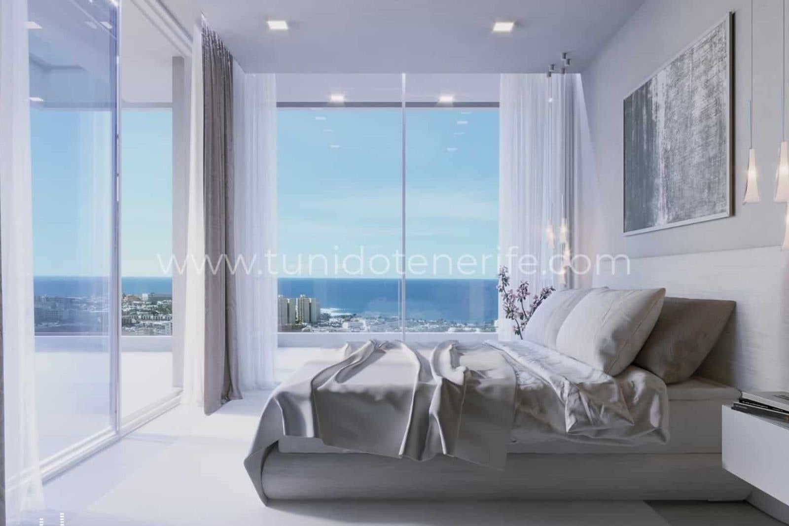 Bright bedroom with bed and large windows facing the sea