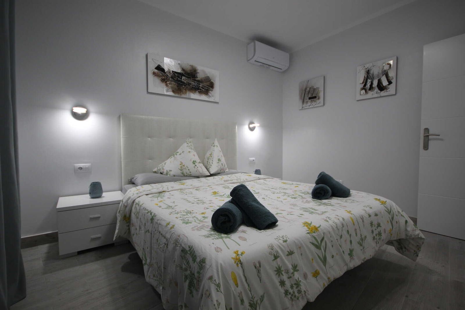Camera da letto con letto matrimoniale, comodini e arredo floreale